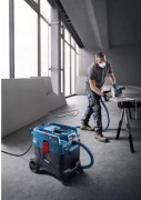 Odkurzacz budowlany Bosch GAS 400 A podłączony do szlifierki podczas odsysania pyłu w warsztacie.